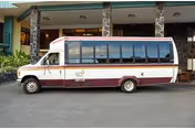 A shuttle bus is parked in front of Life Care Center of Hilo's exterior entrance.