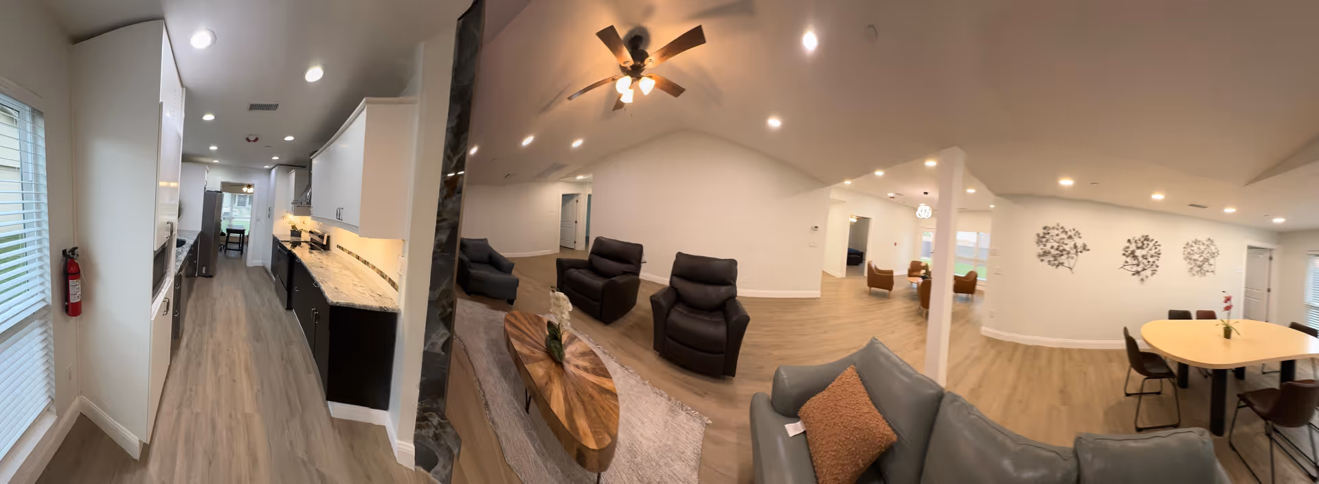 Spacious open-plan interior with kitchen, seating lounge, and dining area in a senior facility.