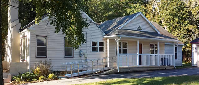 Front exterior view of a single-story assisted living facility with a ramp.