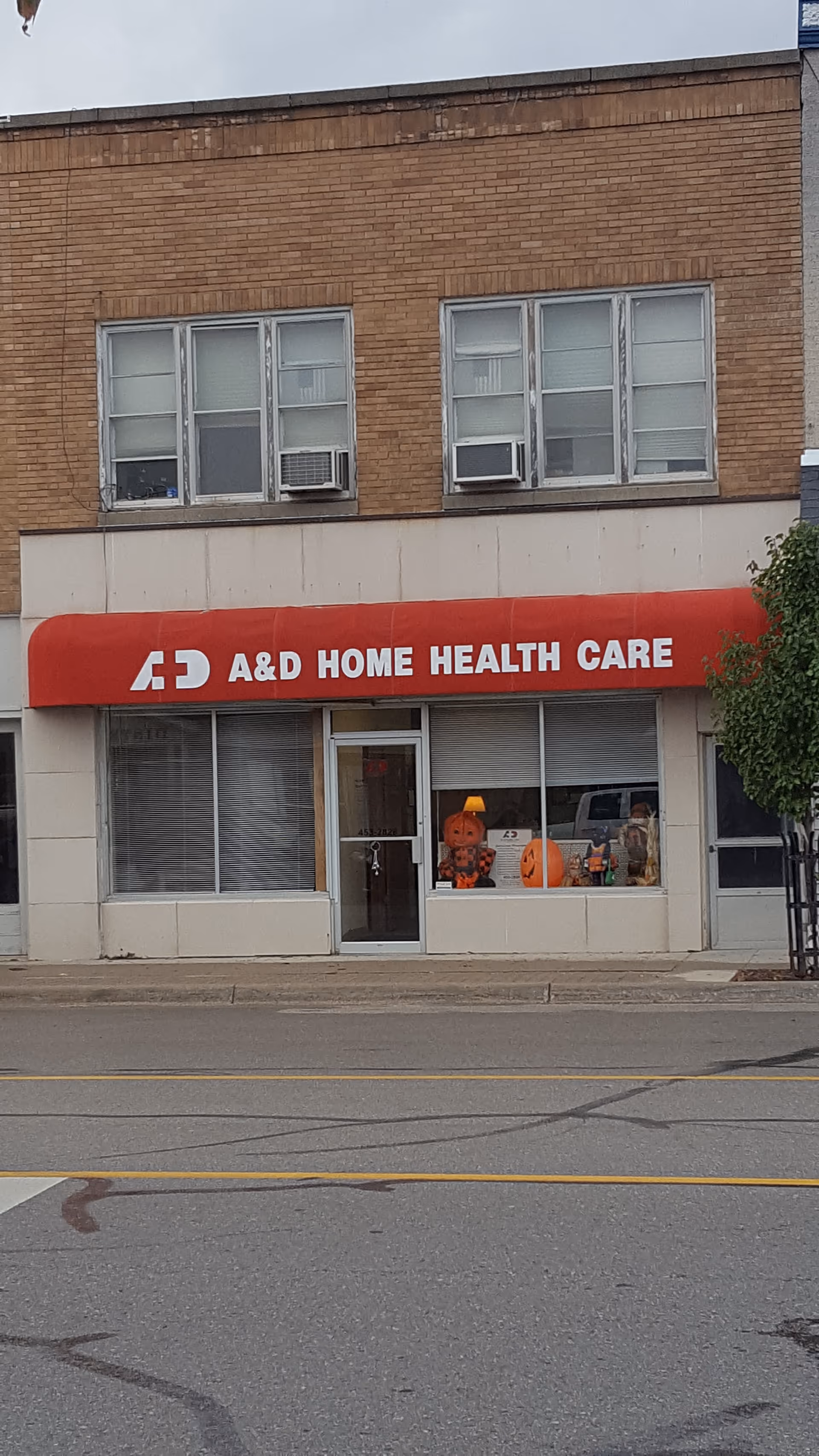 Exterior storefront with red awning reading A&D Home Health Care and windows.