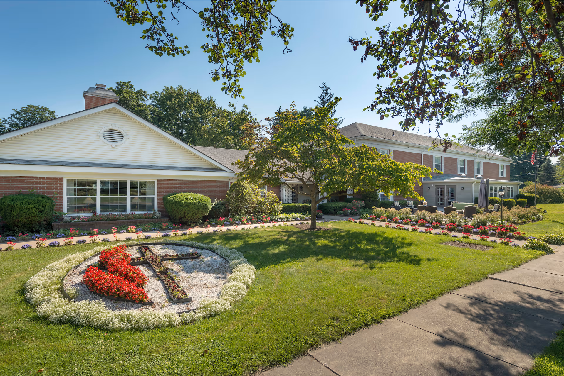 Exterior view of Tunkhannock Manor with manicured lawn and flower beds surrounding the building.