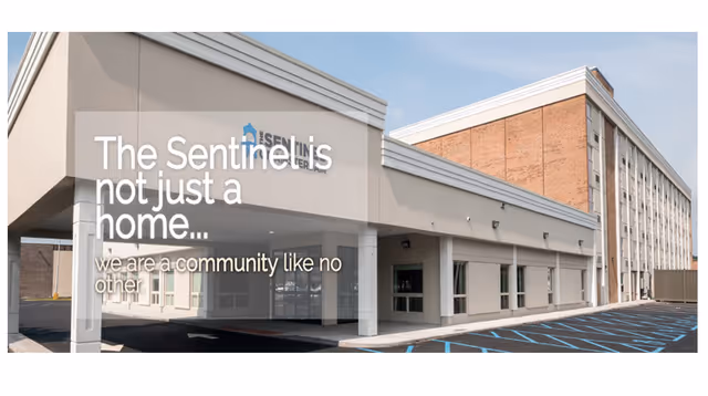 Exterior view of The Sentinel of Amsterdam senior living facility entrance and parking.