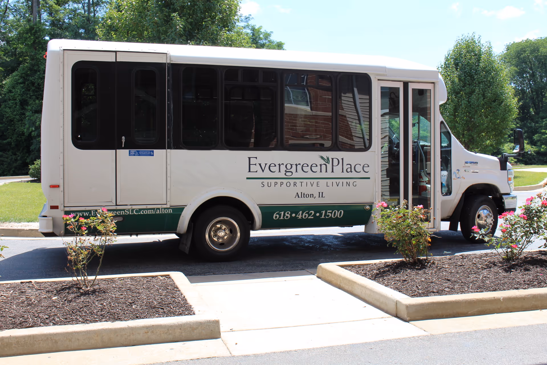 Evergreen Place Supportive Living bus parked outside facility entrance.