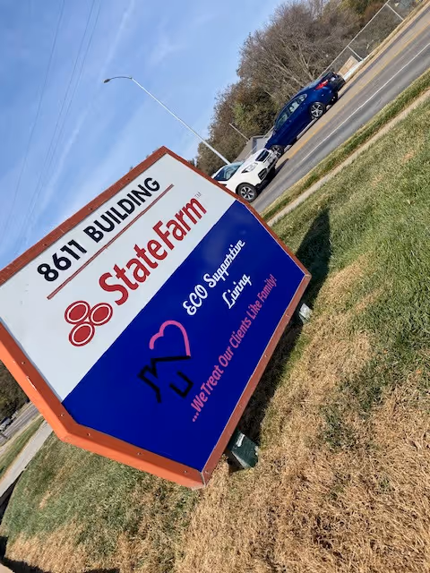 Angled outdoor sign for ECO Supportive Living LLC and State Farm beside the road.