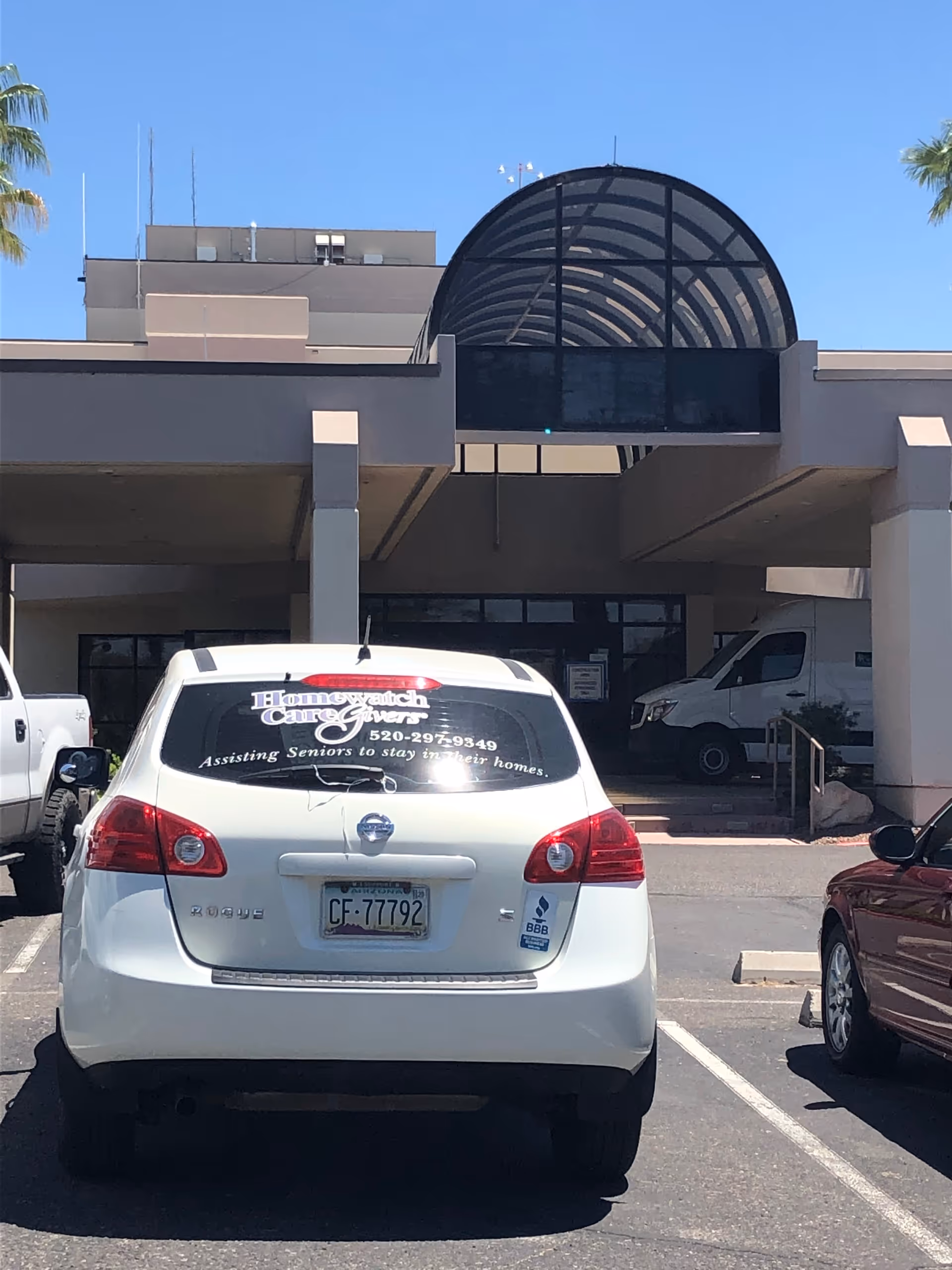Front entrance of Homewatch CareGivers facility with a white vehicle parked outside.
