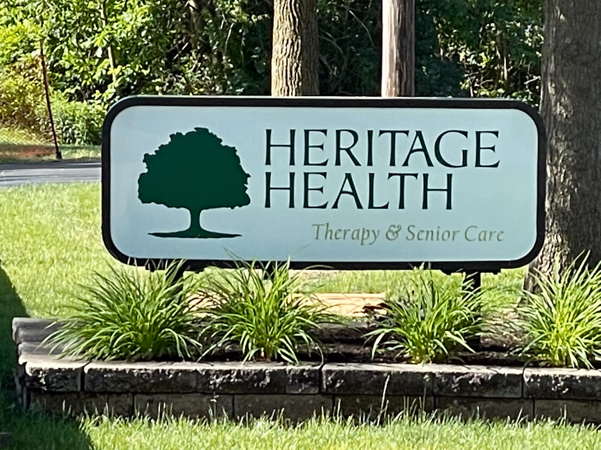 A large outdoor sign with a tree silhouette and Heritage Health text.