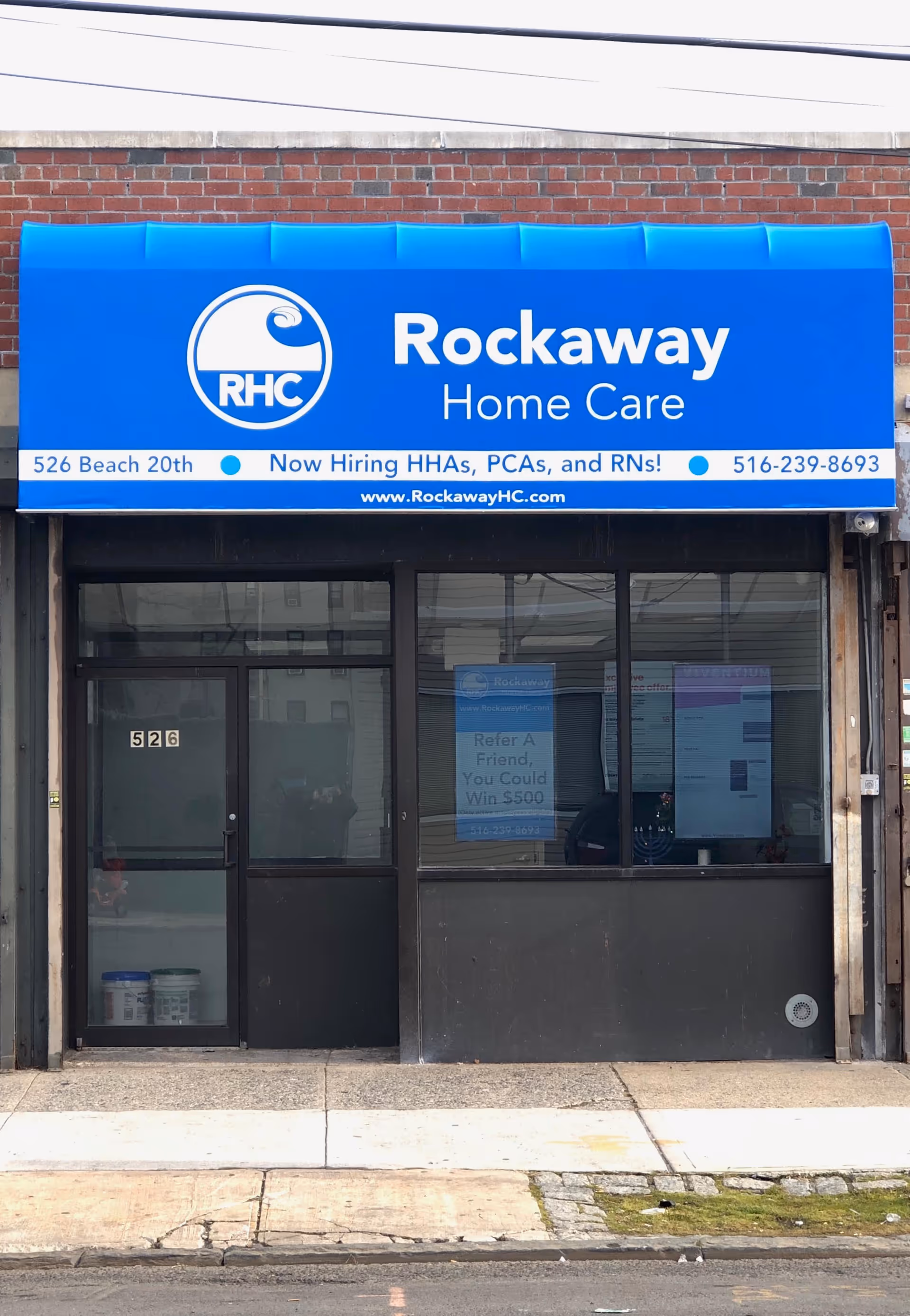 Blue Rockaway Home Care storefront sign above glass-door entrance on brick building.