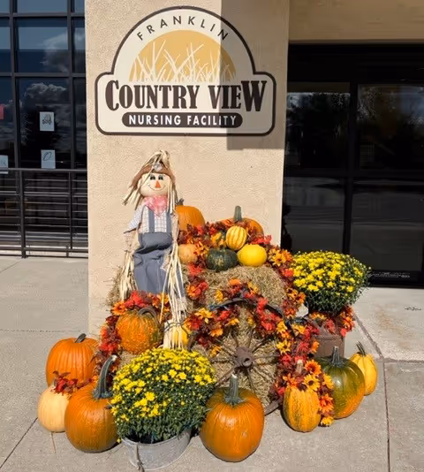 Exterior view of Franklin Country View Nursing Facility entrance decorated with pumpkins and mums.
