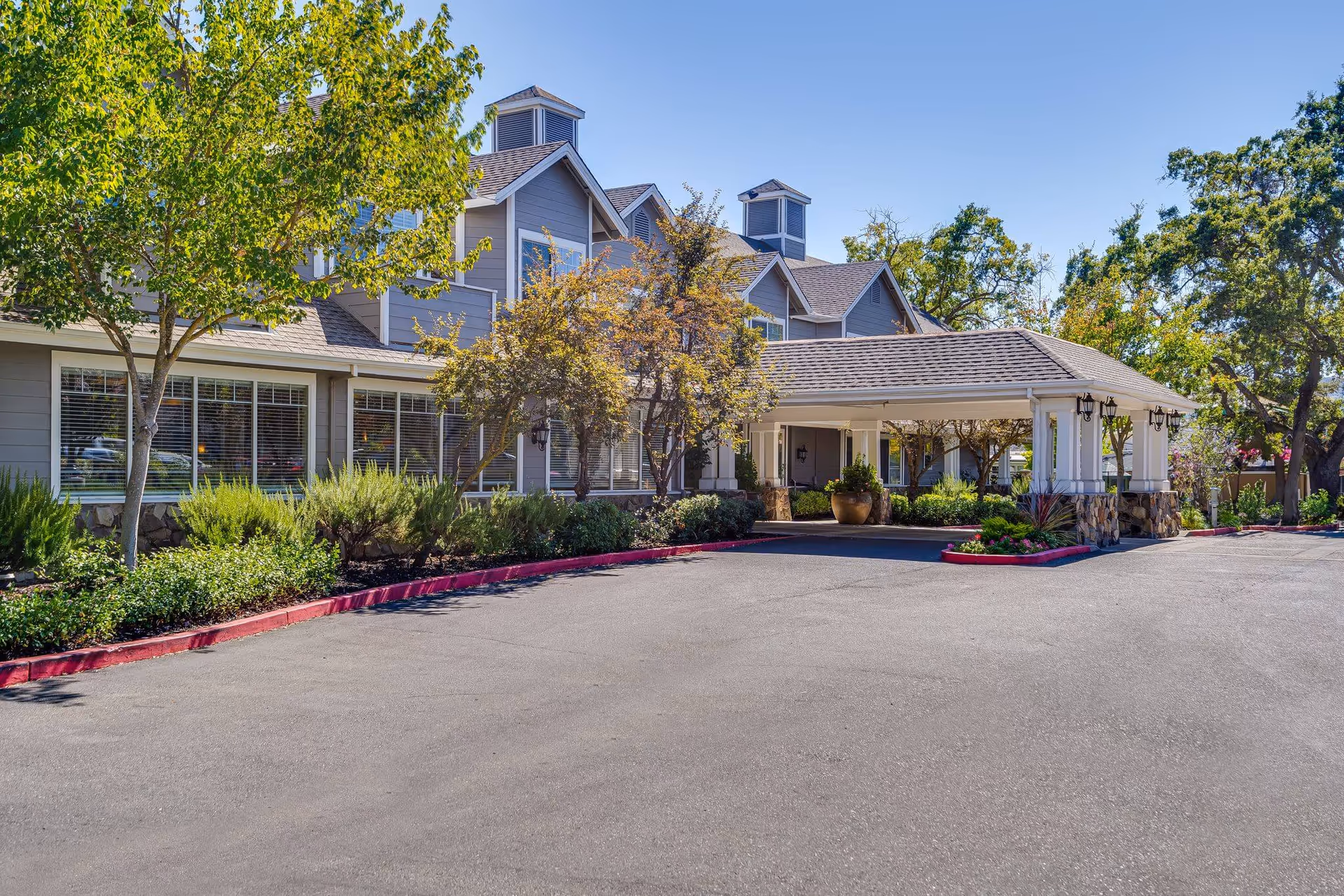 Exterior view of Sunrise of Danville with entrance canopy, driveway, and landscaped surroundings.