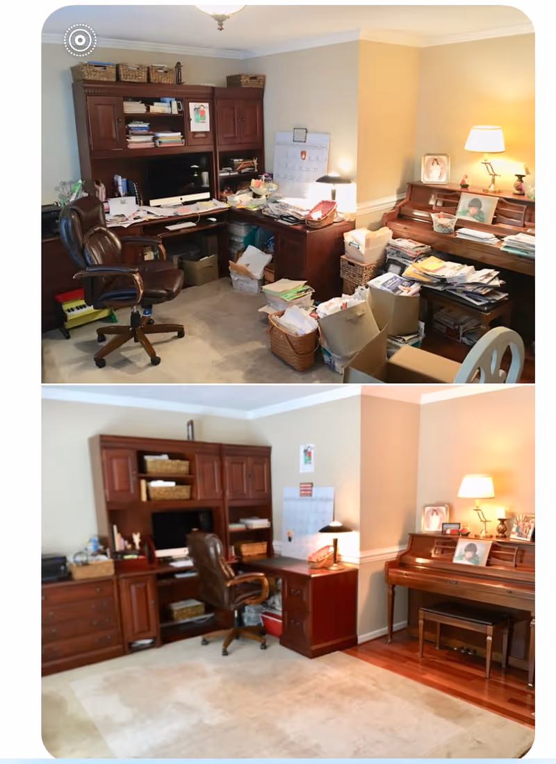 A cluttered home office with two wooden desks, chairs, shelves, and piles of papers.