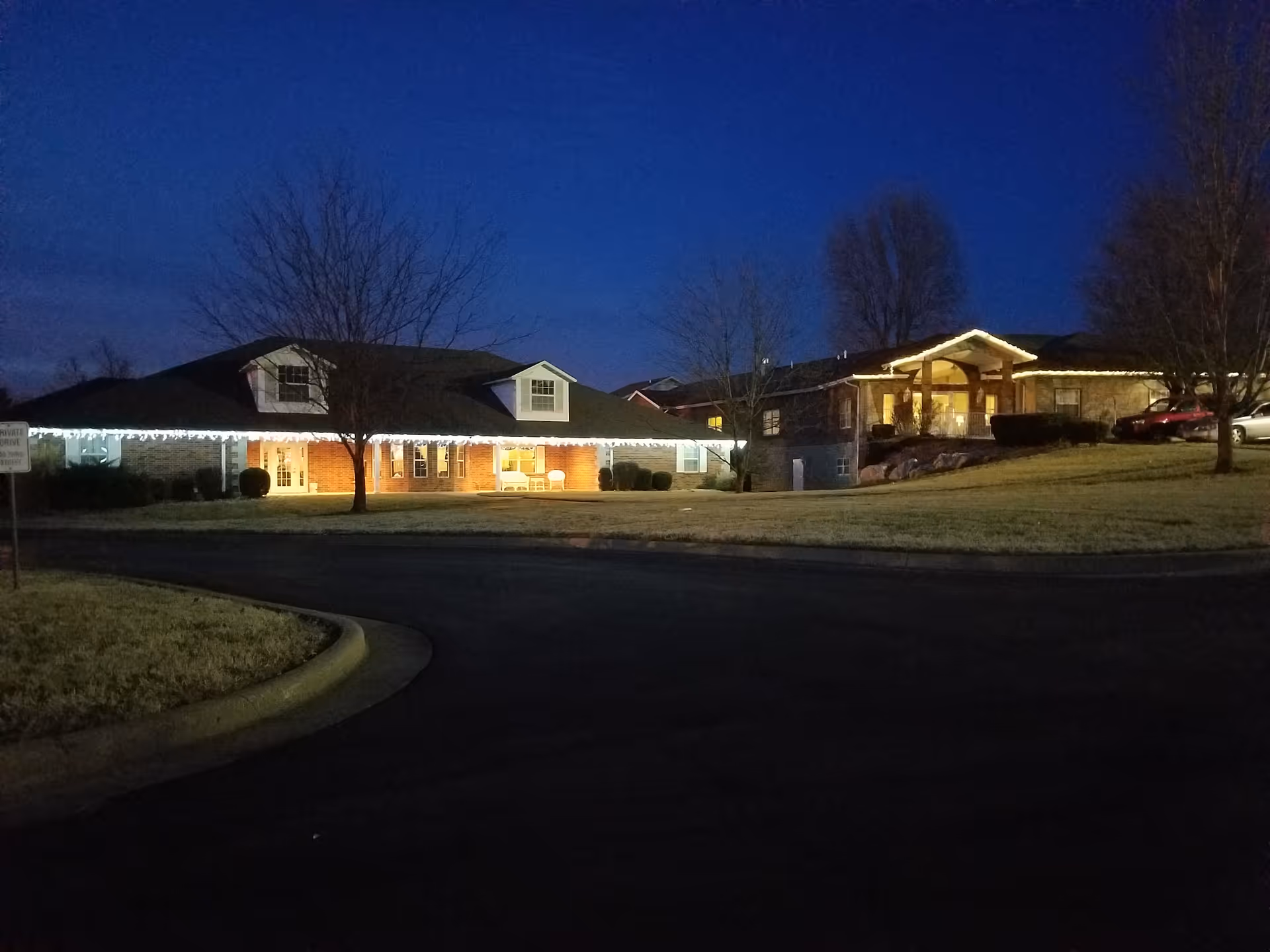 Night view of Lacoba Homes exterior with lit porches and string lights along the entrance.