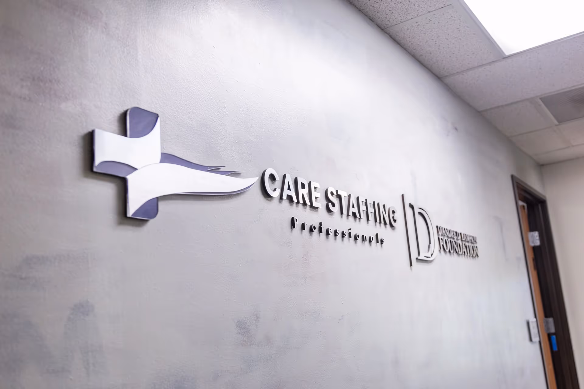 Interior hallway wall displays a Care Staffing Professionals sign and logo.