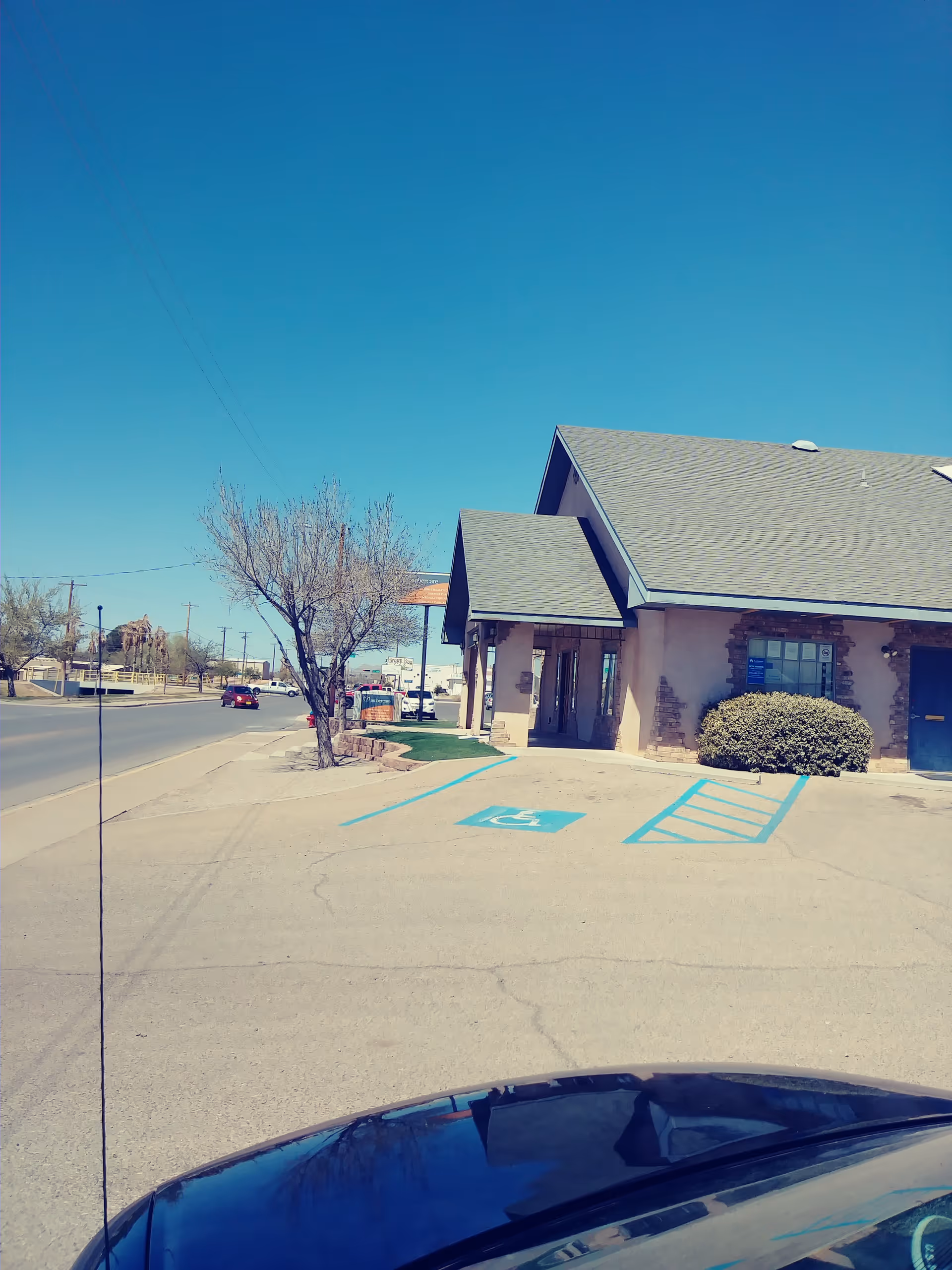 Sunny exterior view of Ambercare facility with handicap parking and entrance.