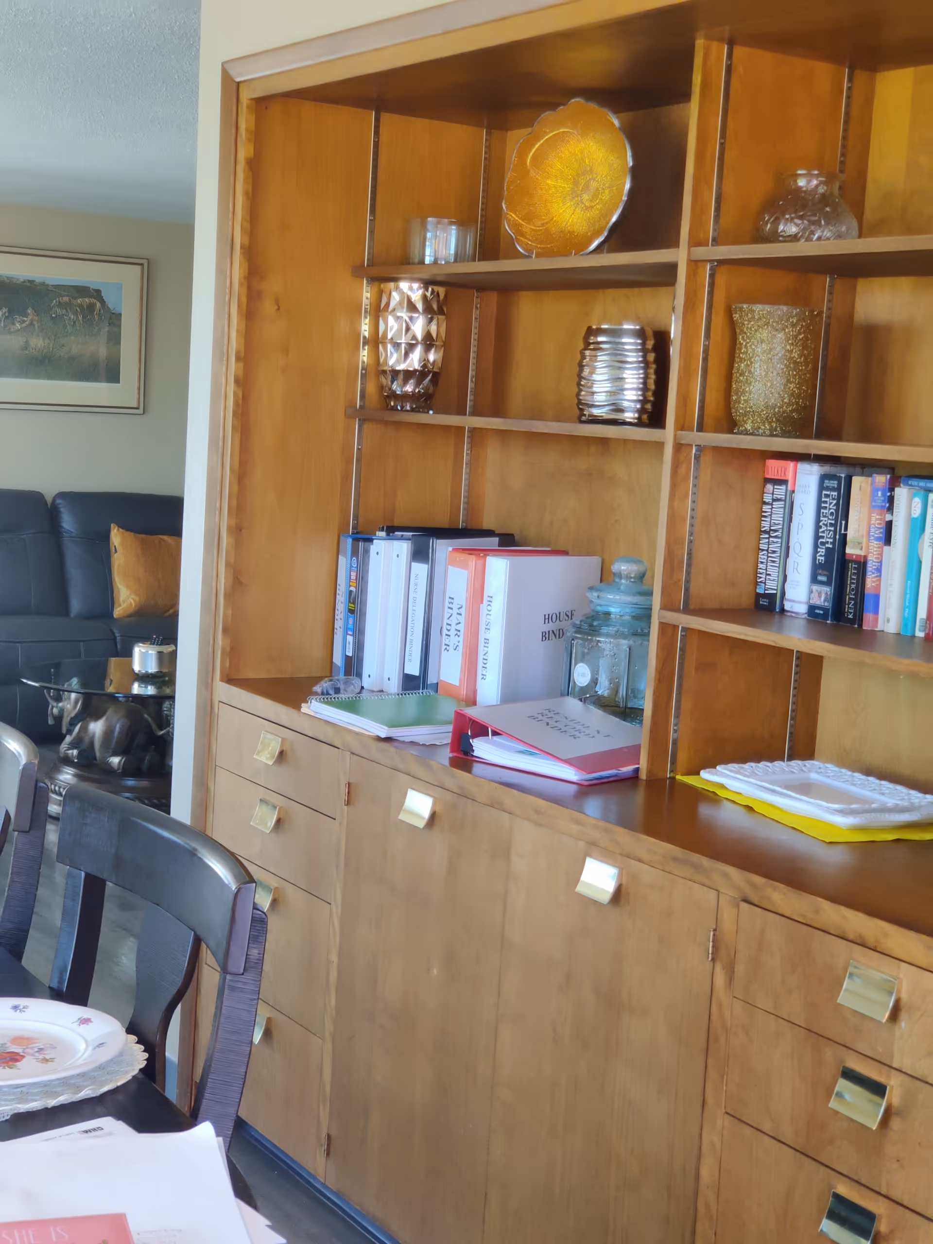 Wooden dining cabinet with shelves, books, and decorative items.