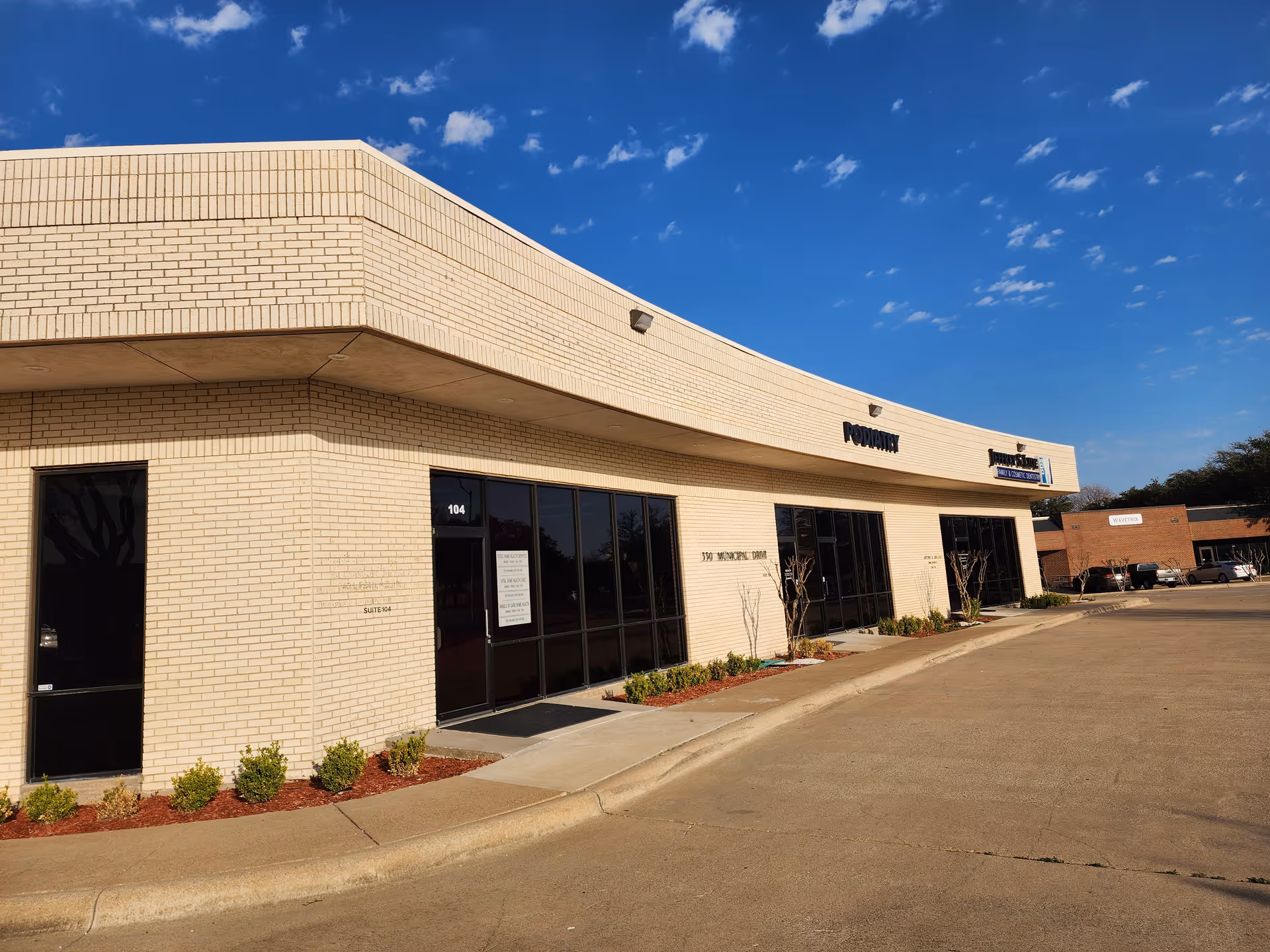 Exterior view of Vital Home Health Care storefront in a beige brick building.