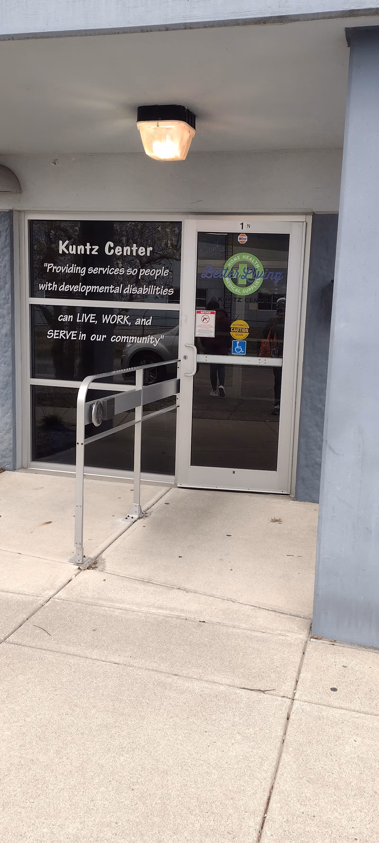 Front entrance of Kuntz Center with glass doors and wheelchair accessibility ramp.