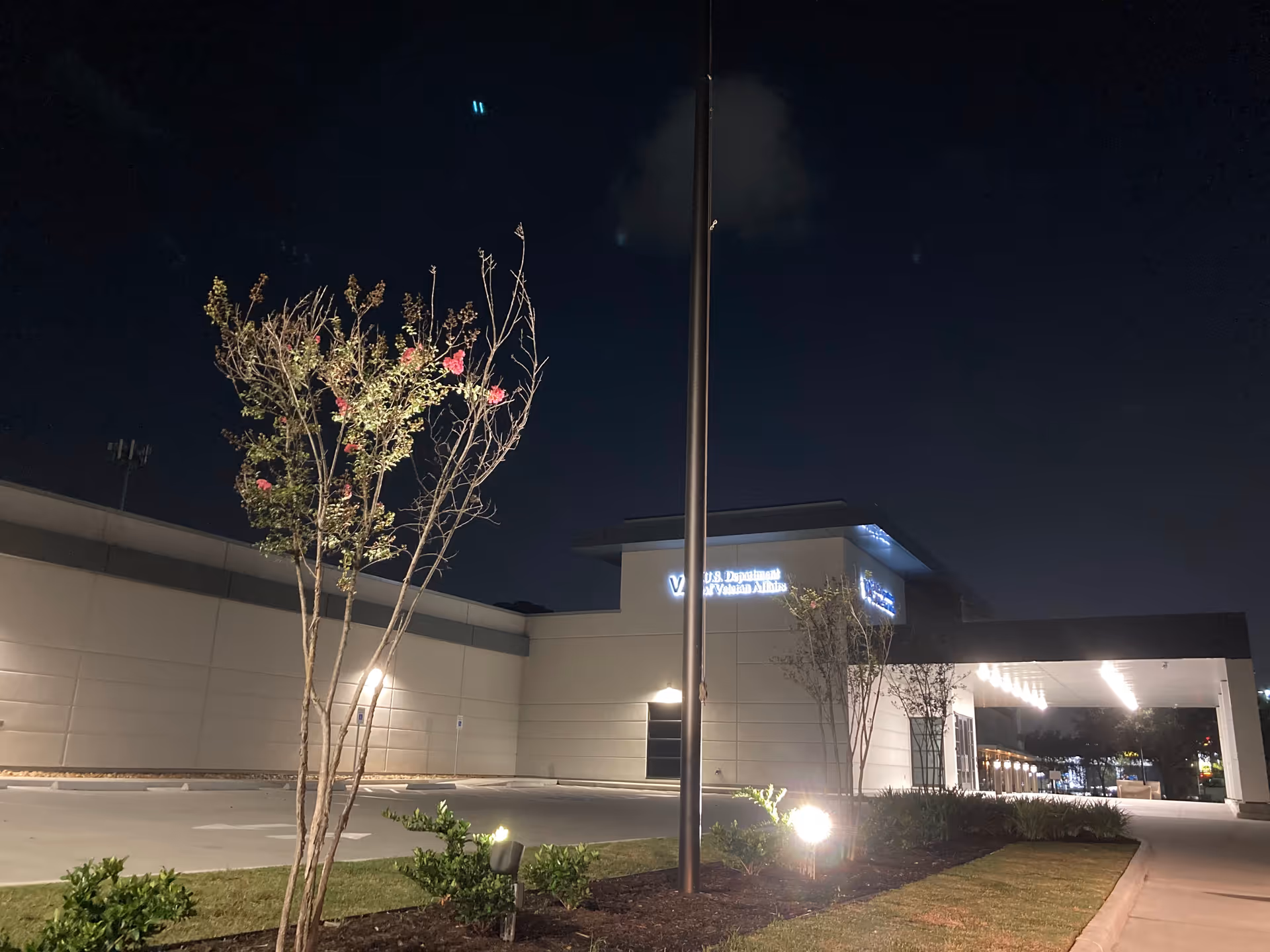Night exterior of a U.S. Department of Veterans Affairs facility with illuminated entrance.