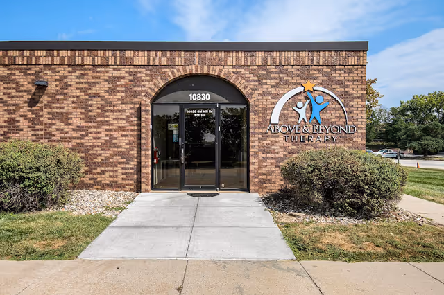 Brick facility entrance with glass doors and Above and Beyond Therapy sign.