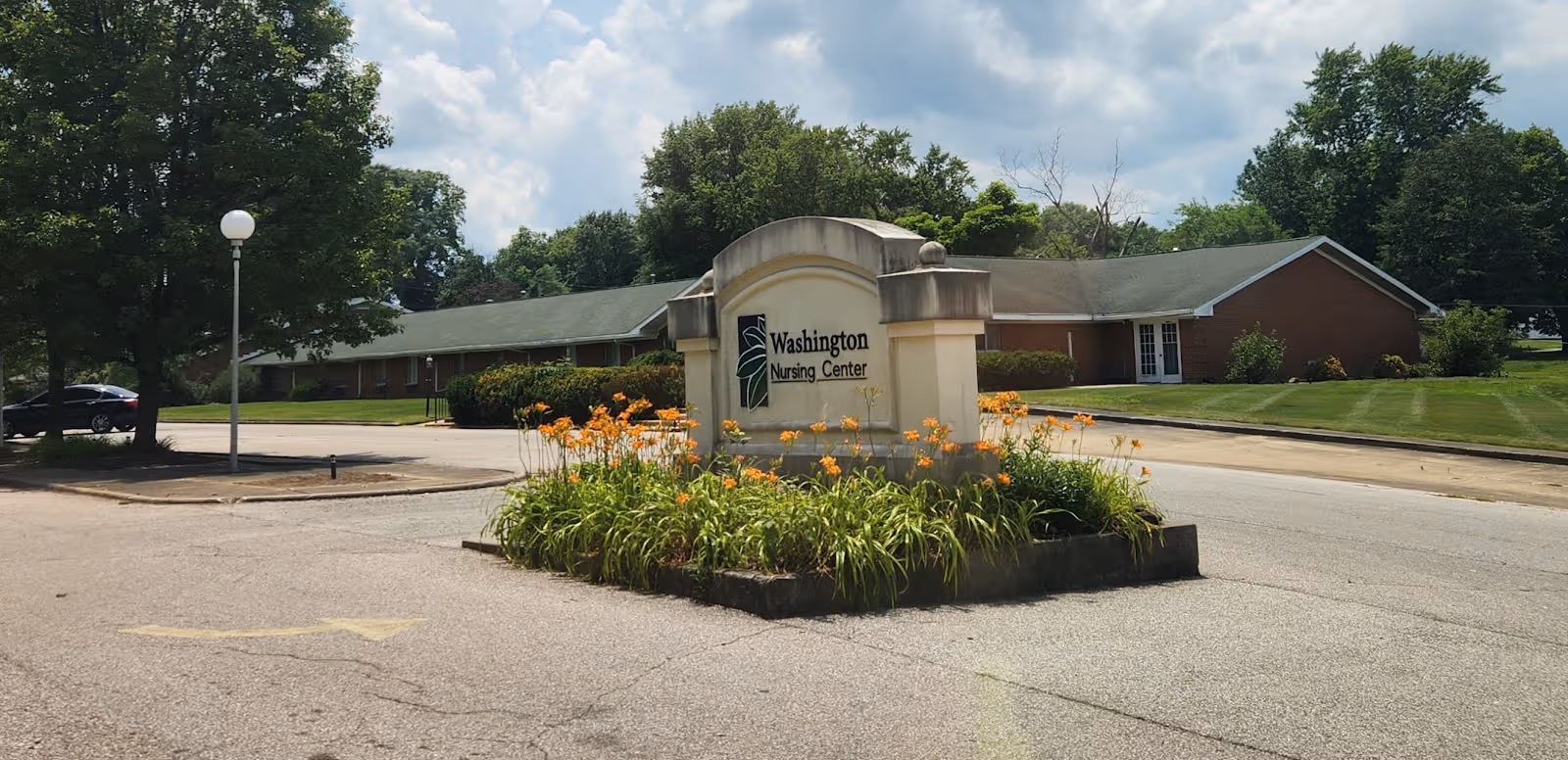 Exterior view of Washington Nursing Center with landscaped entrance sign and brick building