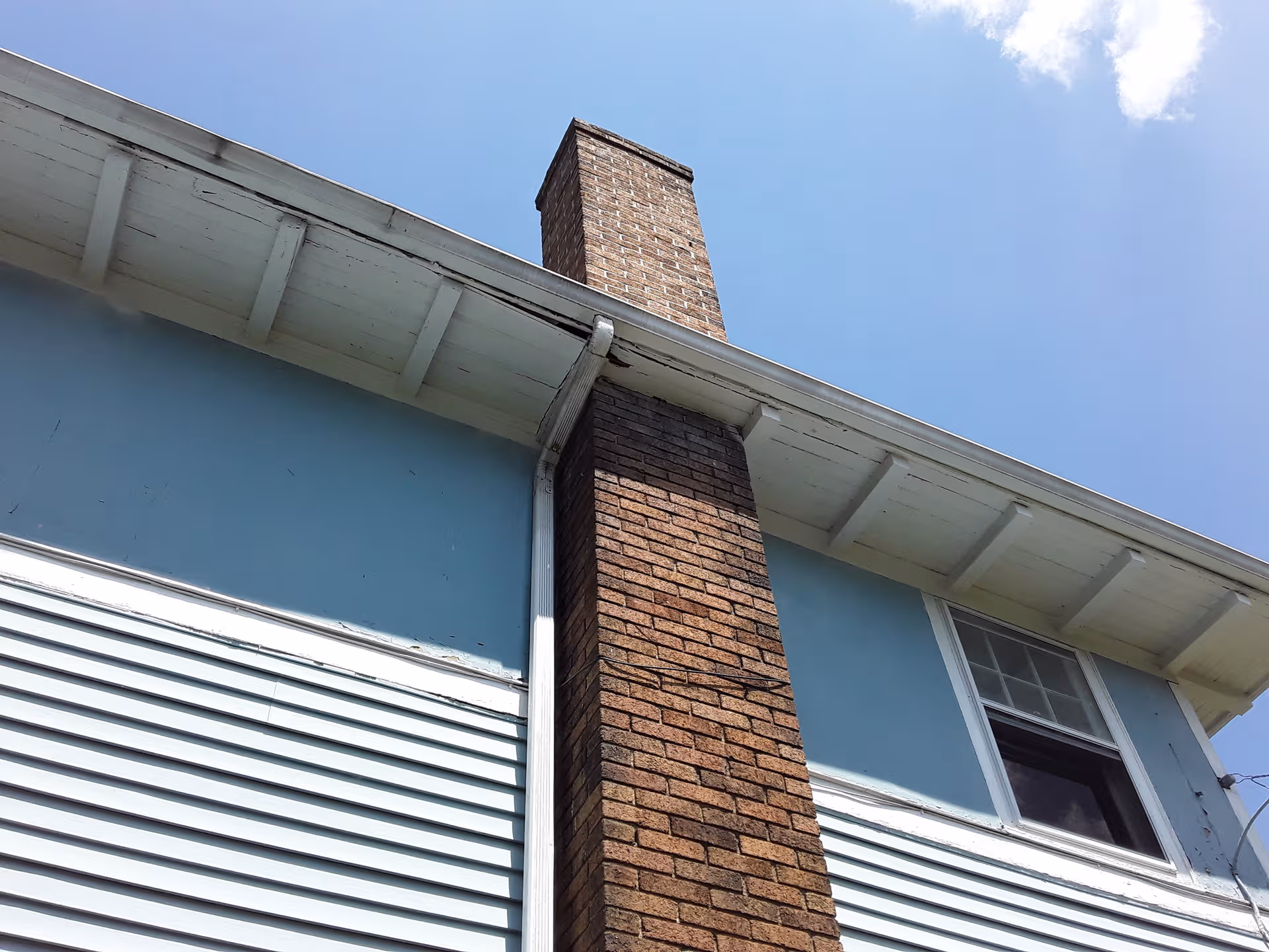 Blue two-story Bedford Specialized Care II building exterior with a brick chimney and white trim.