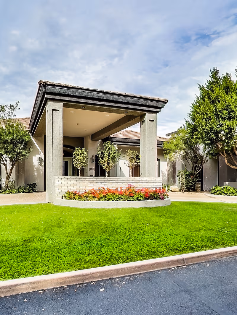 Front view of a modern assisted living facility entrance with a manicured lawn