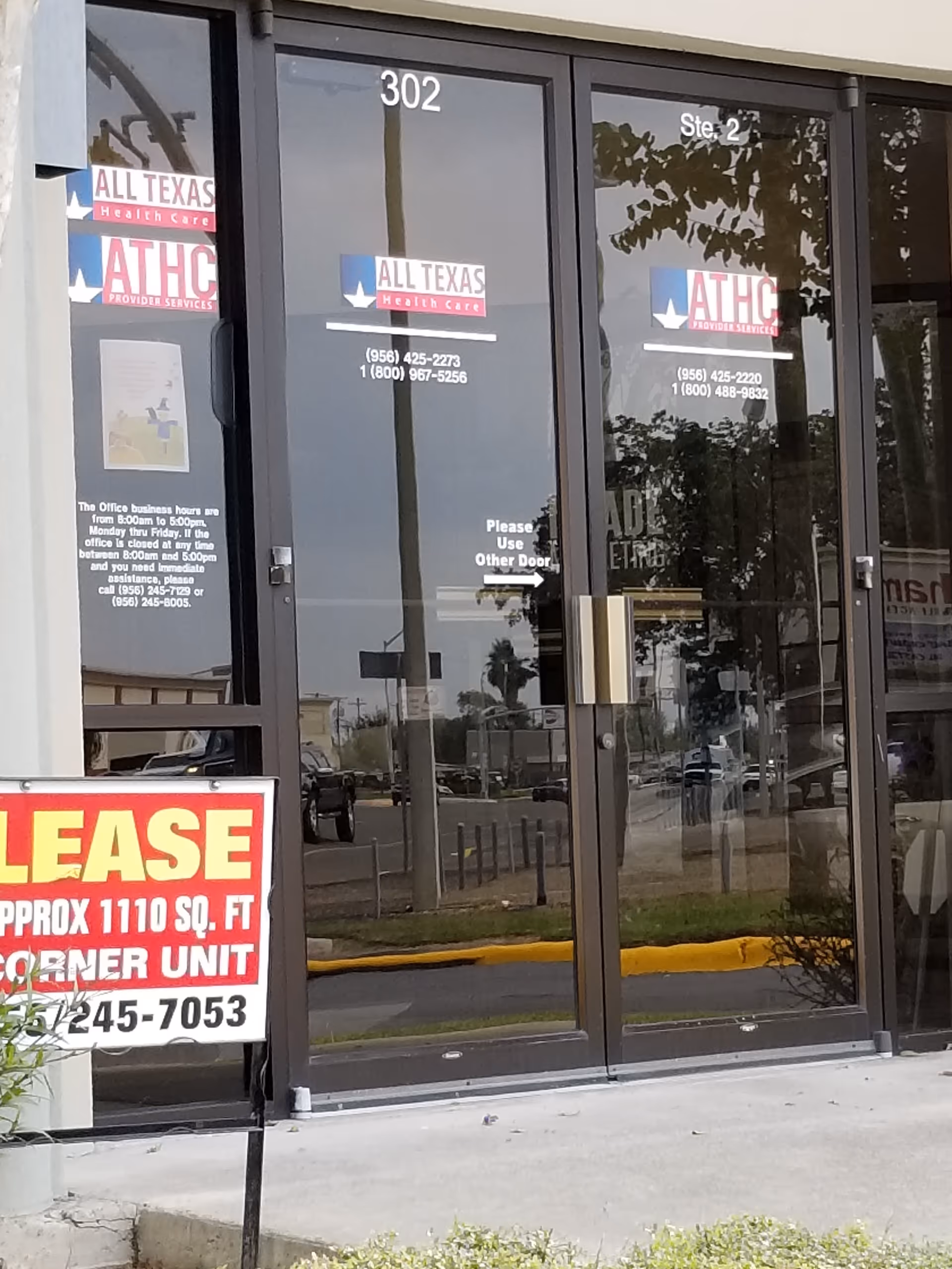 Glass entrance with ATHC Provider Services logos and a large lease sign outside building