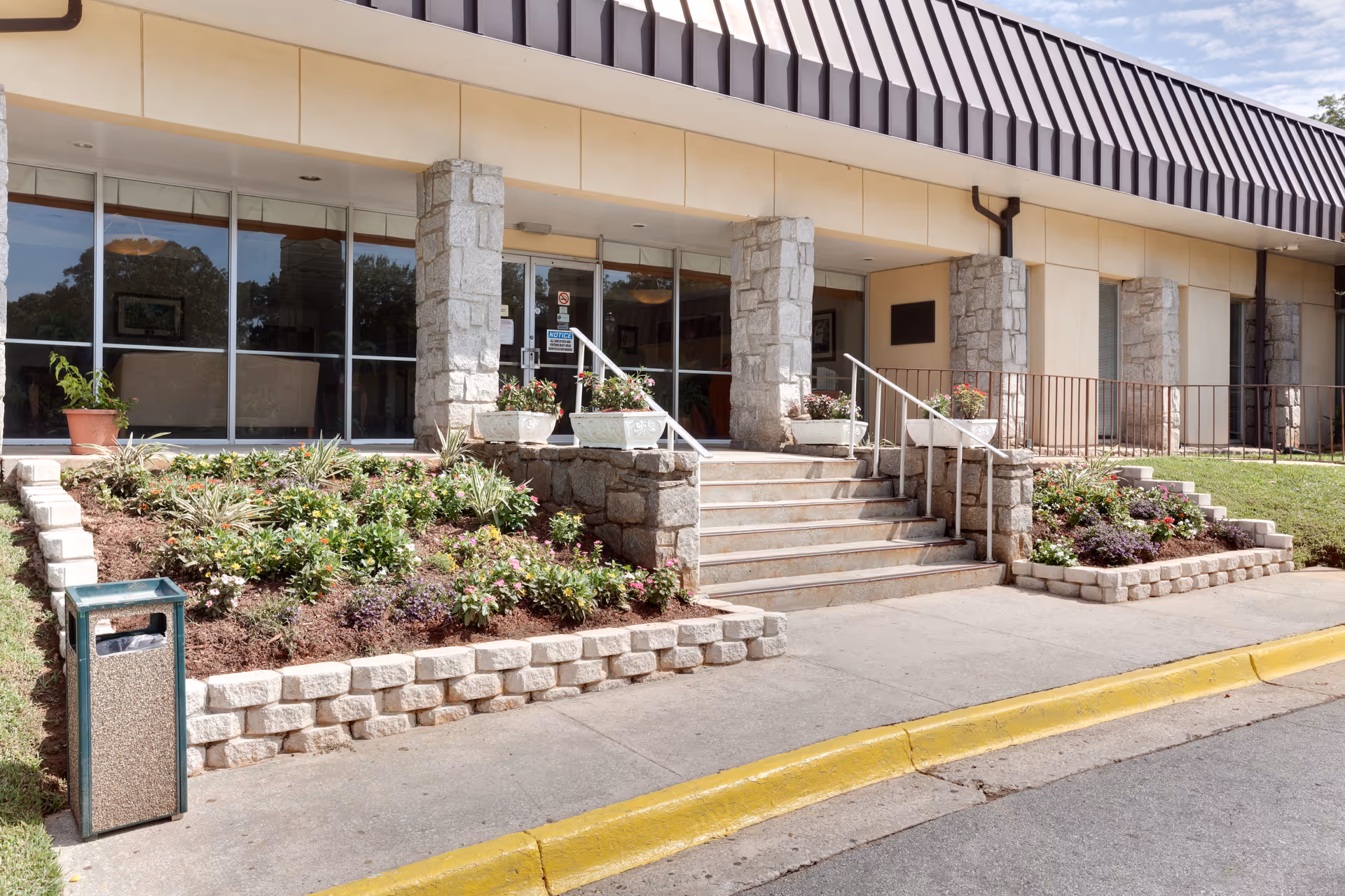 Exterior view of Sadie G. Mays Health & Rehabilitation Center with glass doors and stone columns.