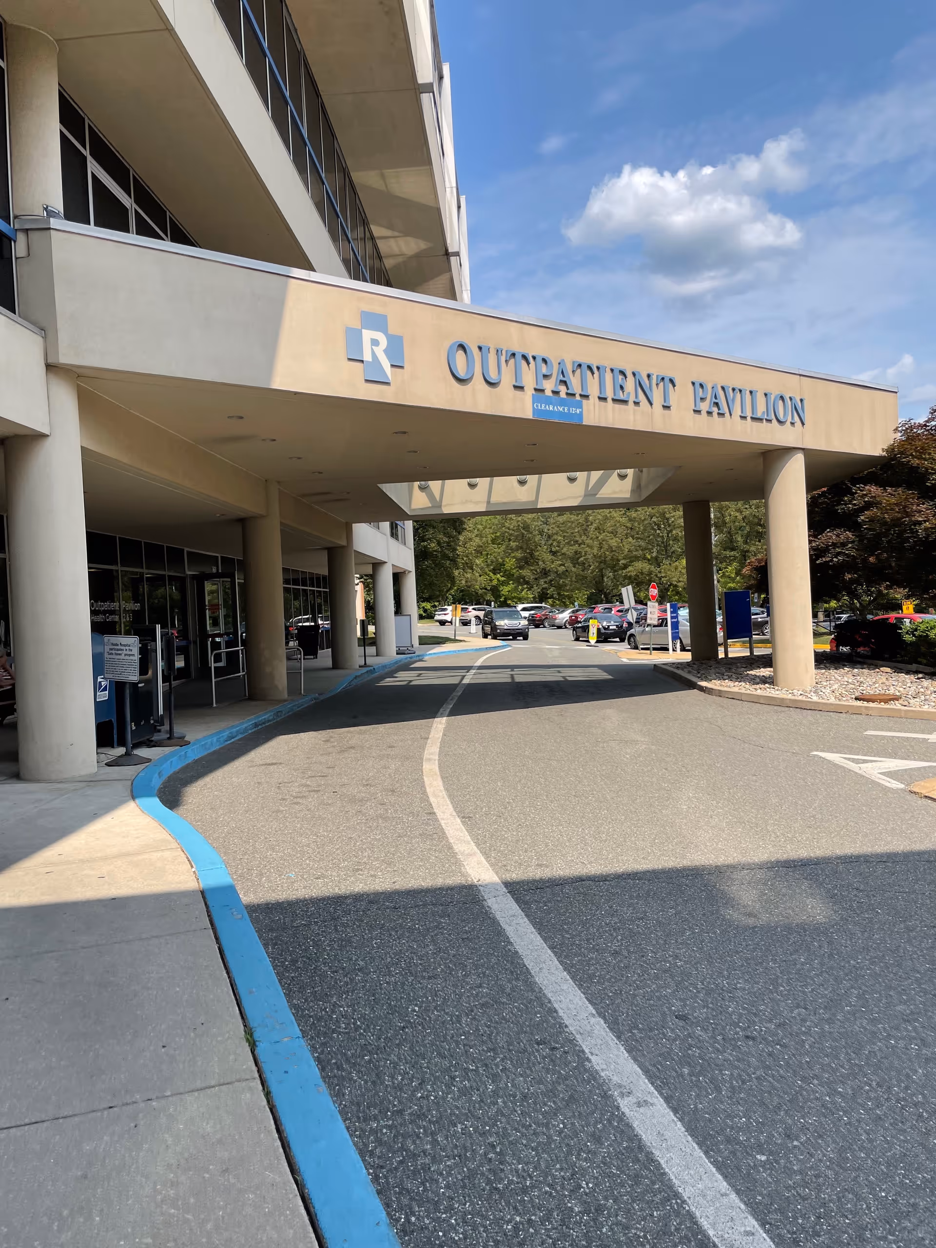 Exterior view of hospital entrance labeled Outpatient Pavilion with a curved driveway.