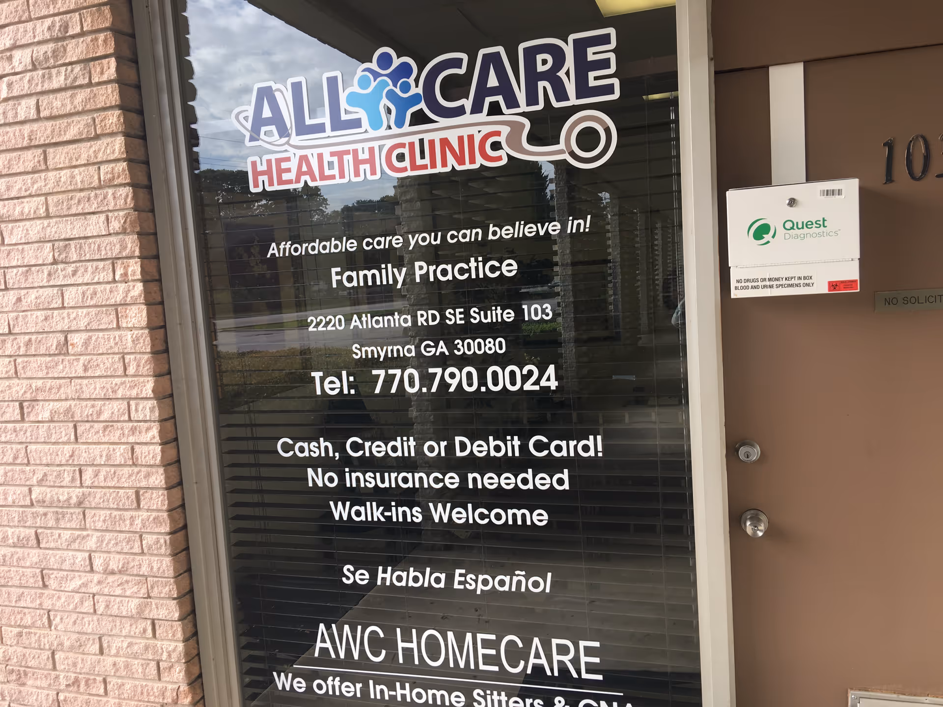 Glass storefront window displaying All Care Health Clinic signage and contact details.