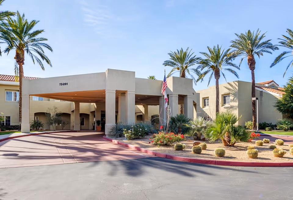 Exterior view of Bayshire Rancho Mirage entrance with palm trees and desert landscaping.