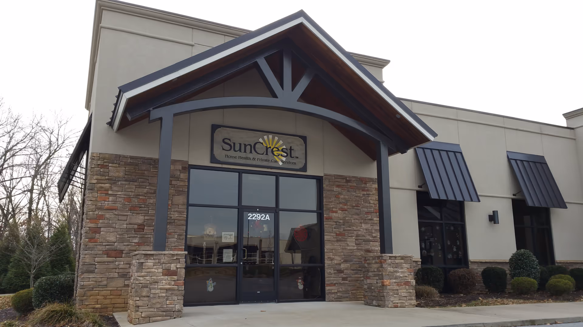 Exterior view of SunCrest Home Health entrance with stone facade and glass doors