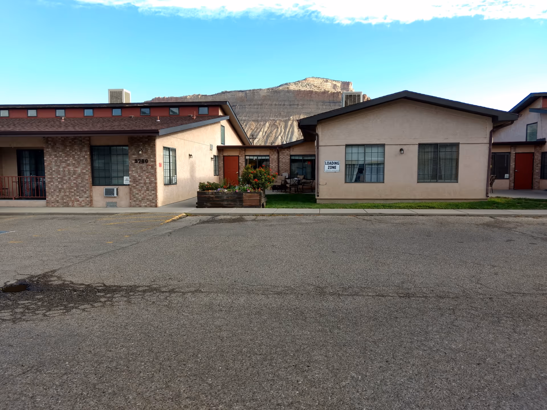 Exterior view of Retreat at Palisade senior living campus with mountains behind.