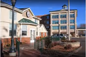 Exterior view of a two-building senior living facility with brick accents and landscaping.