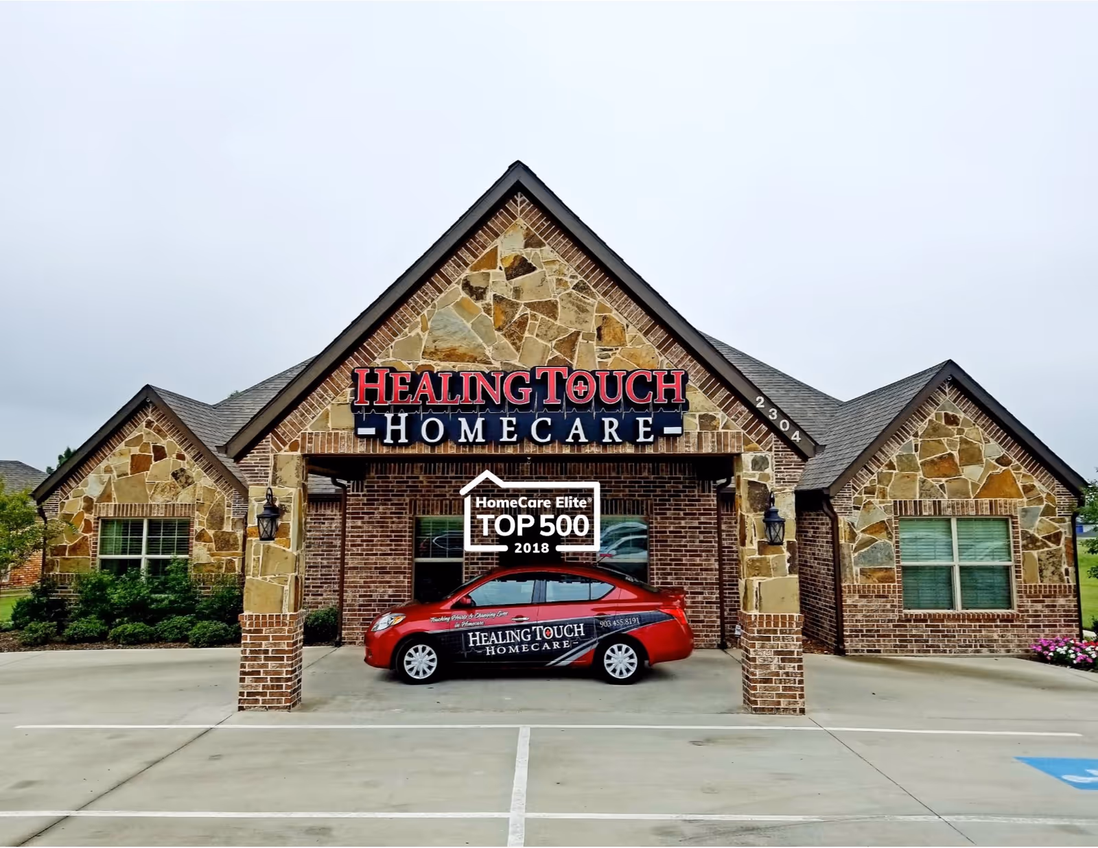 Stone-and-brick building exterior with Healing Touch Homecare signage and a red car in front.
