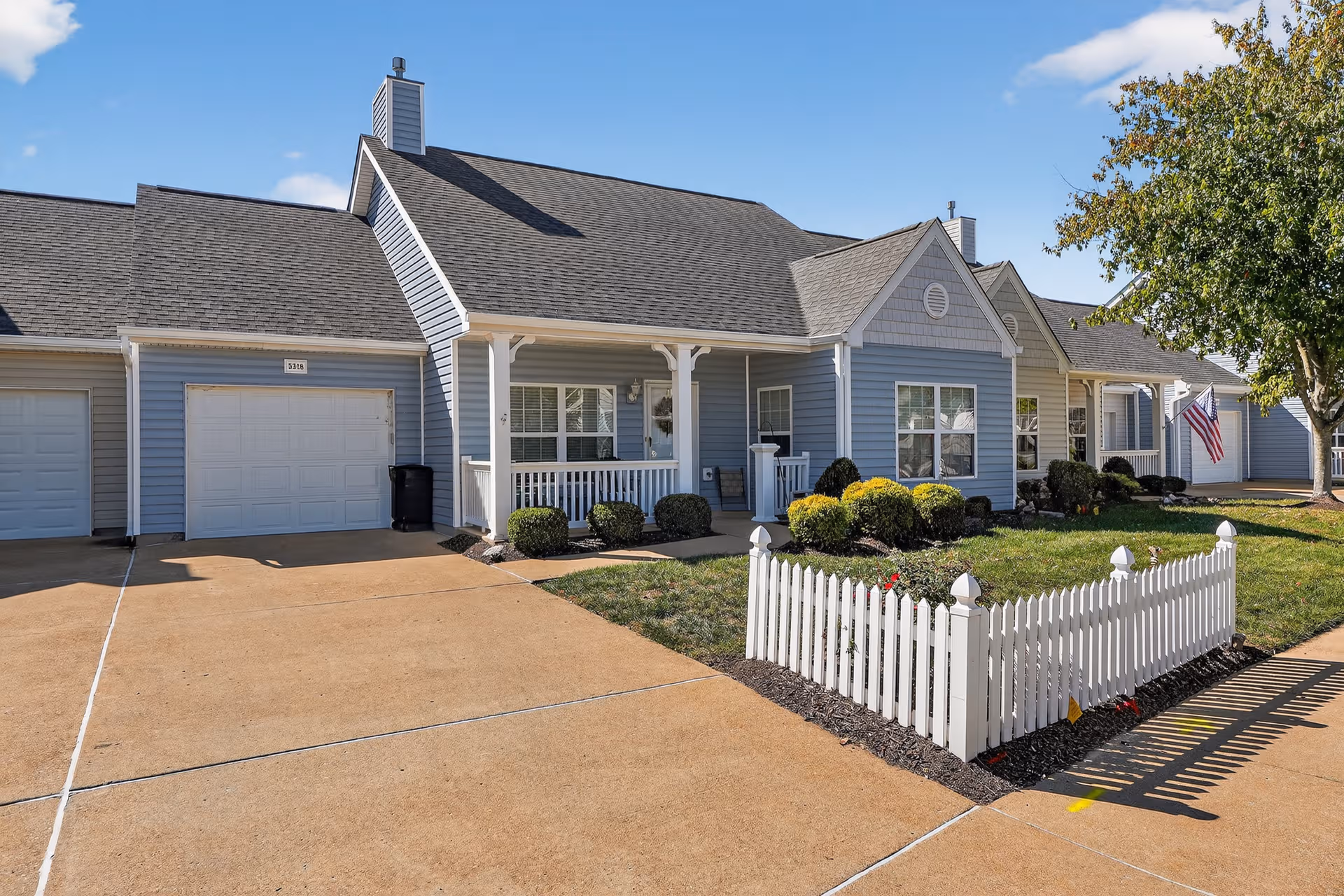 Cape Albeon Assisted Living building with blue siding, white trim, and a white picket fence.