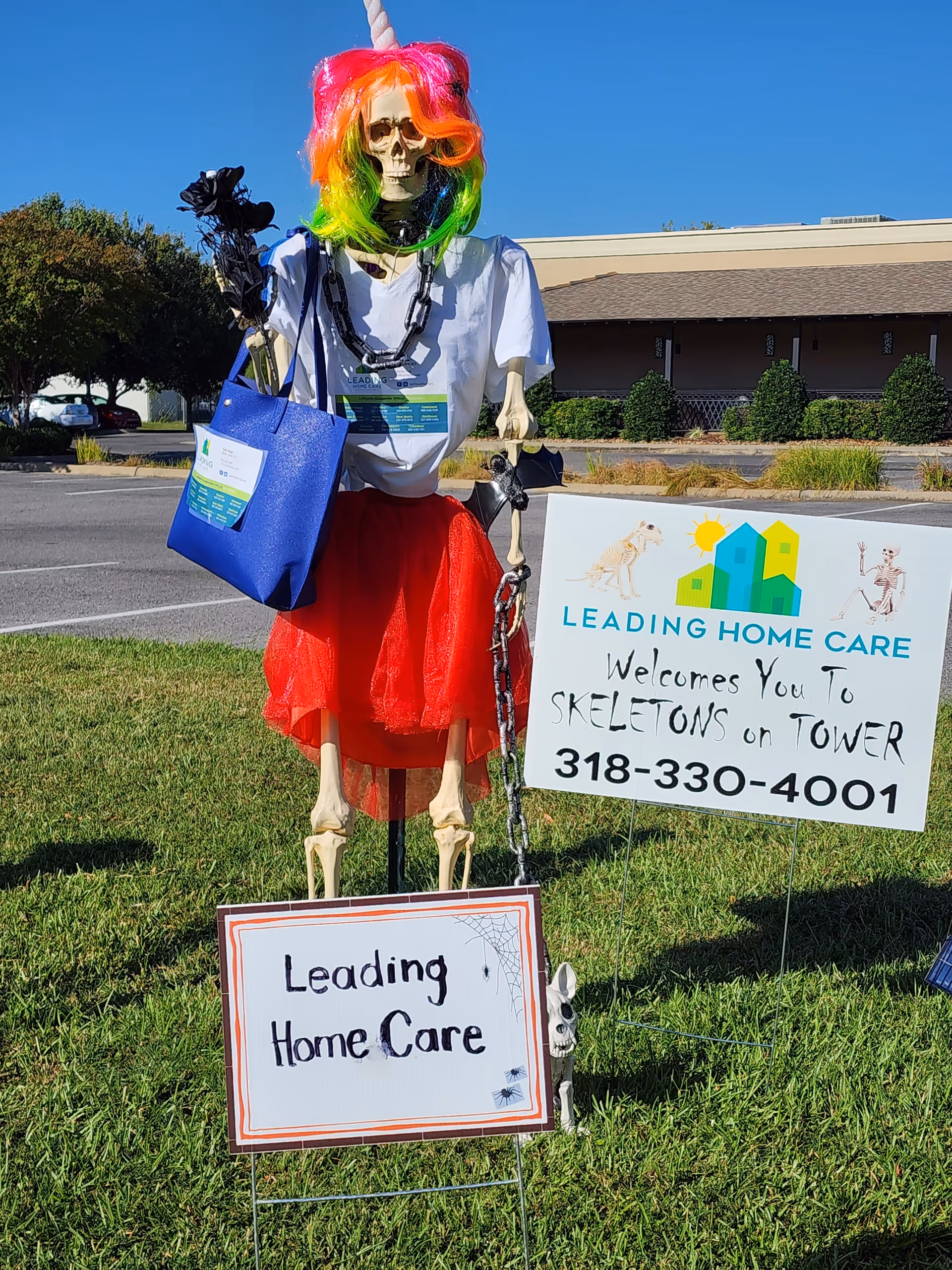 Rainbow-wig skeleton display with Leading Home Care signs outside the Monroe facility.