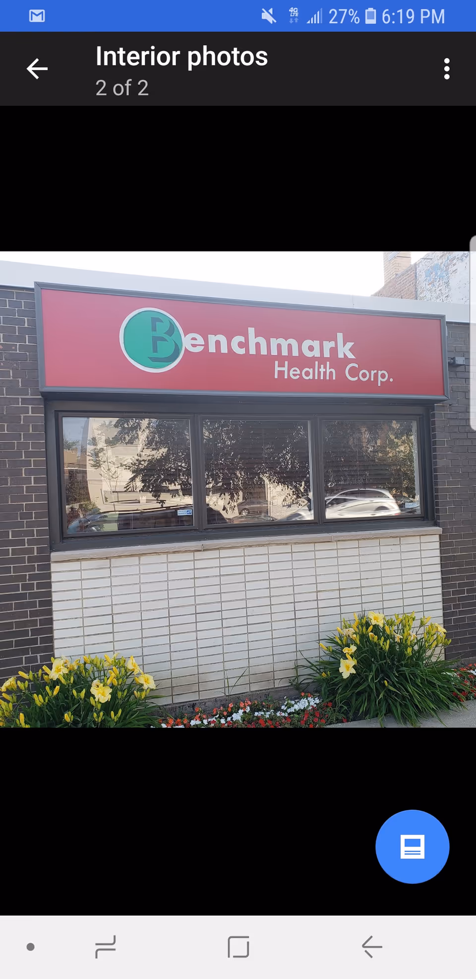 Exterior view of Benchmark Health Corp sign on brick building.
