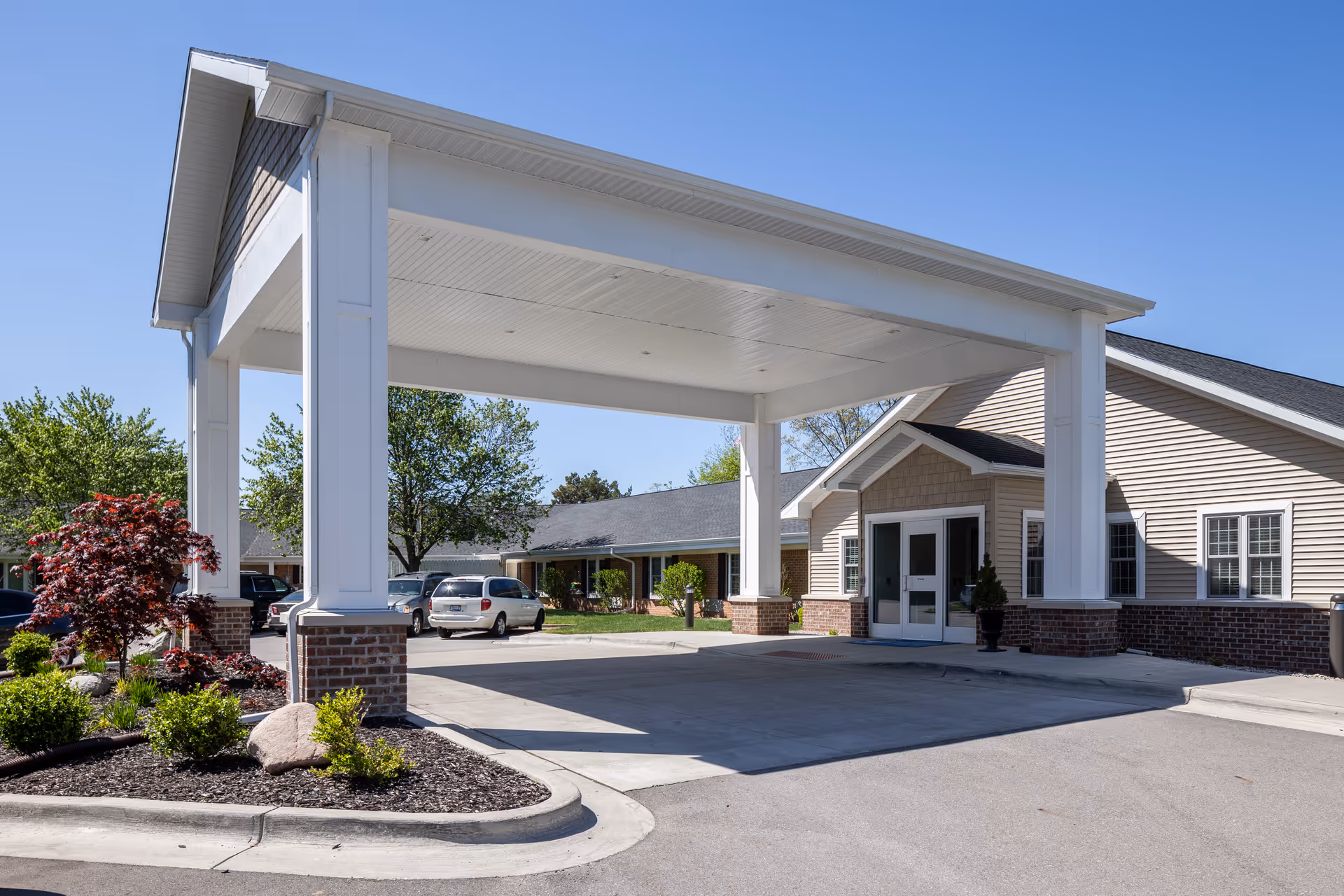White porte-cochere entrance over a driveway at Commonwealth Senior Living at Grand Rapids.
