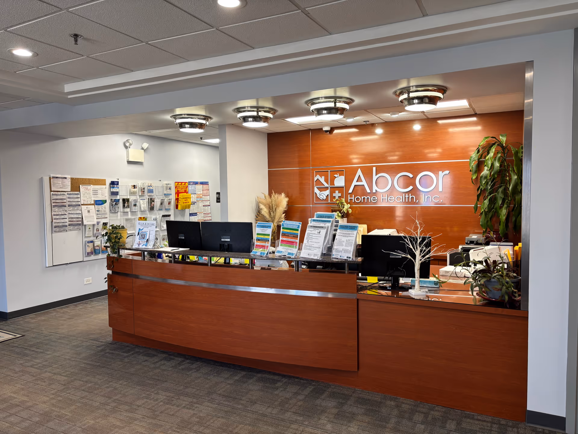 Polished reception desk in a modern lobby under an Abcor Home Health sign.