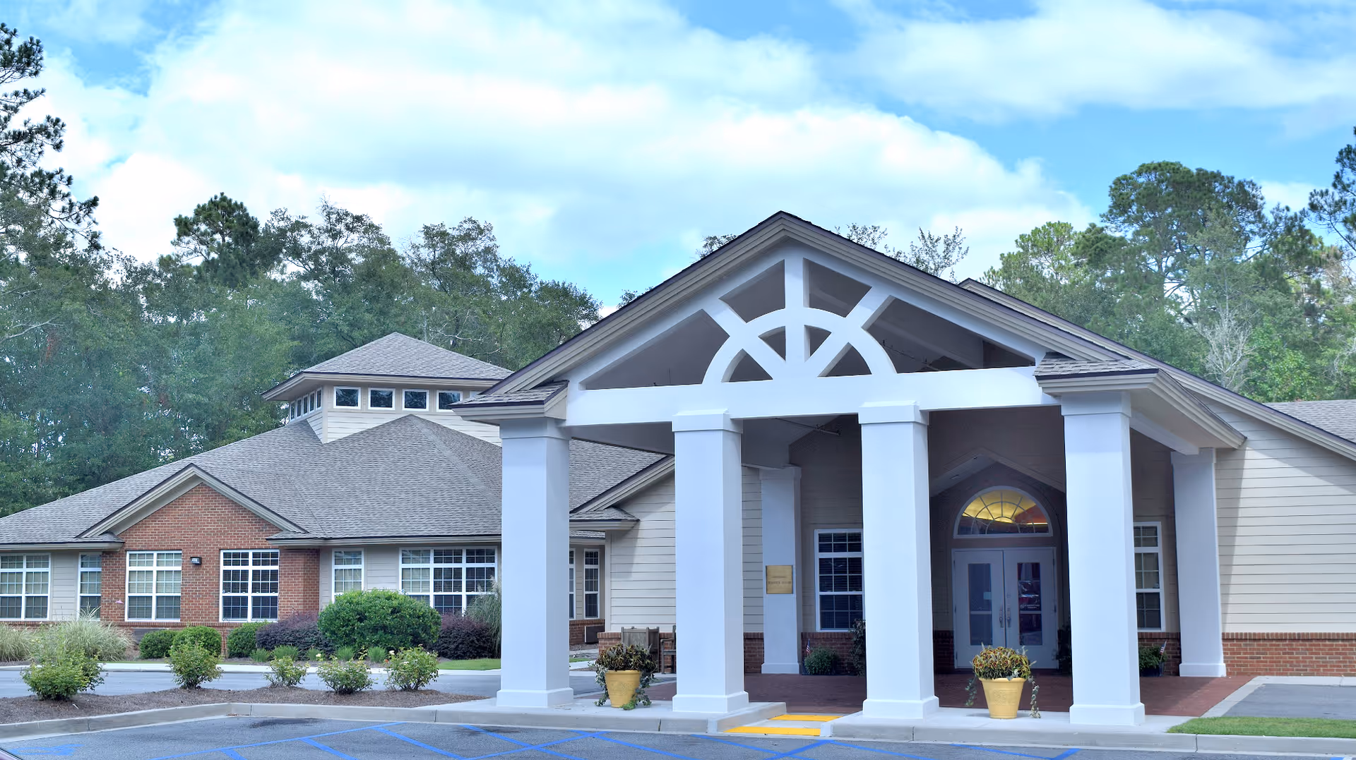 Hospice building with a covered front entrance and white columns.