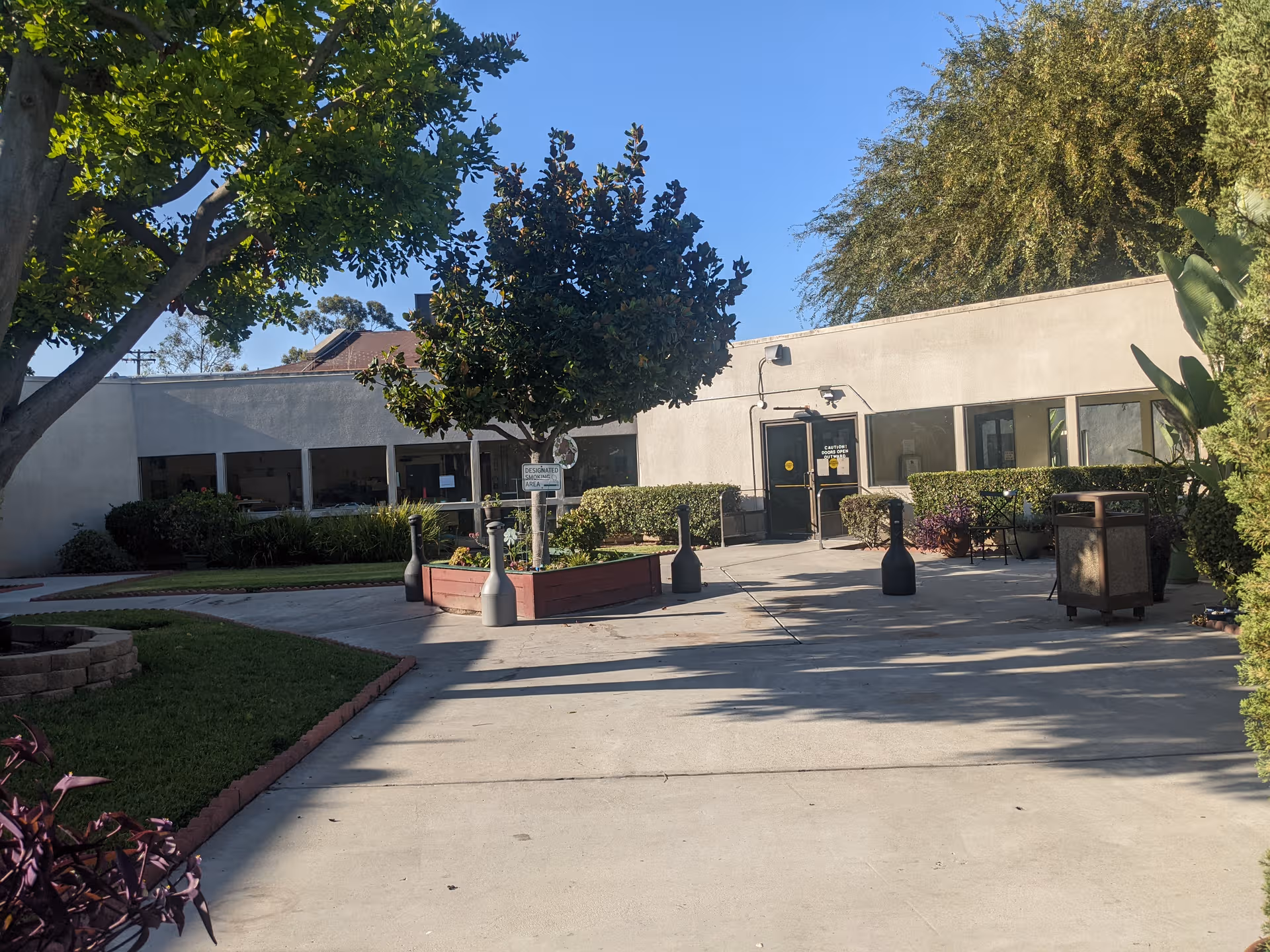 Exterior view of Jacob Healthcare Center front entrance with trees, planters, and seating.