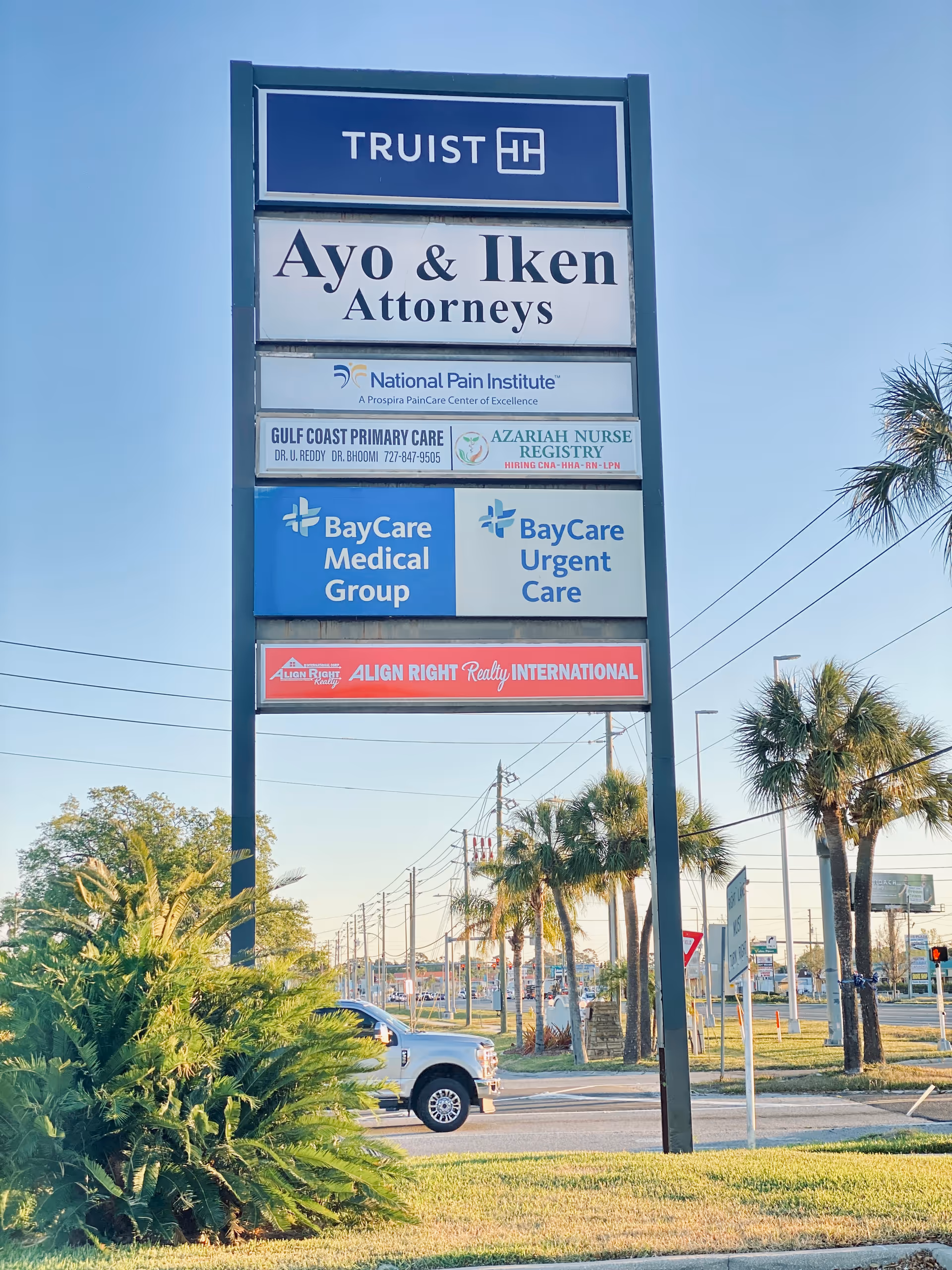 Tall outdoor sign displaying Azariah Nurse Registry beside a road.