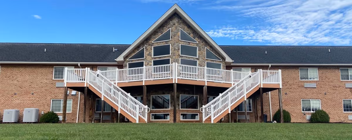 Exterior view of Shenandoah Senior Living building with a central glass atrium and white staircases.