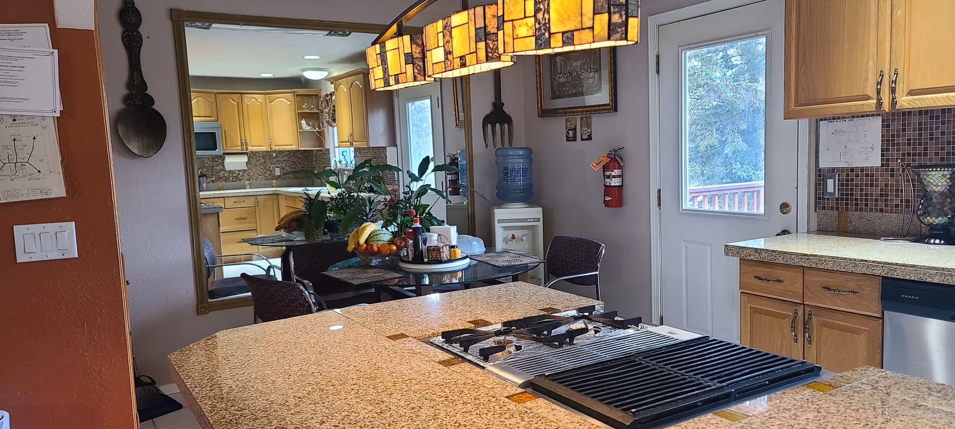 This open-concept kitchen features a granite island, stove, cabinetry, and an adjacent dining area.