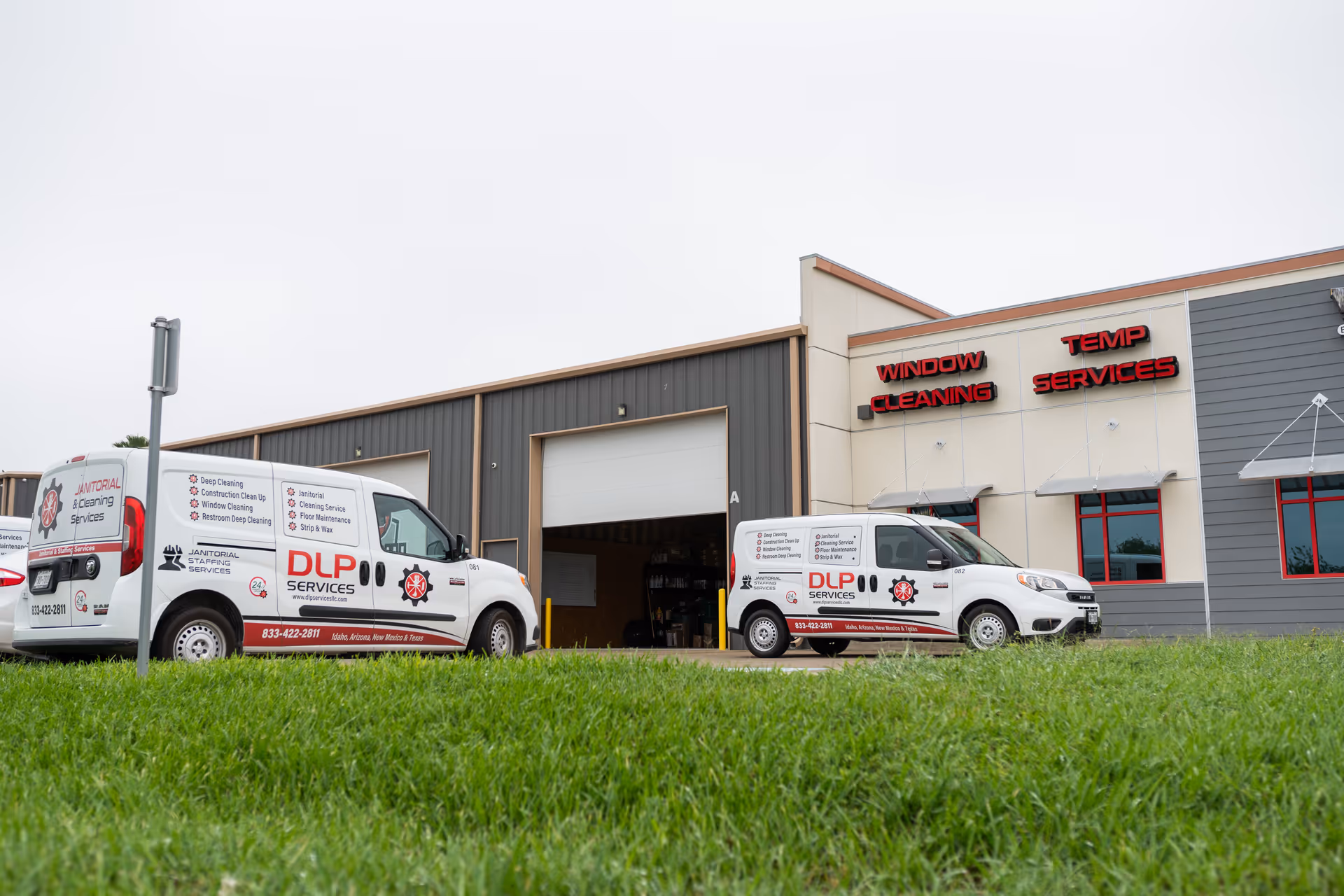 Two DLP Services vans parked in front of a building with service signs.