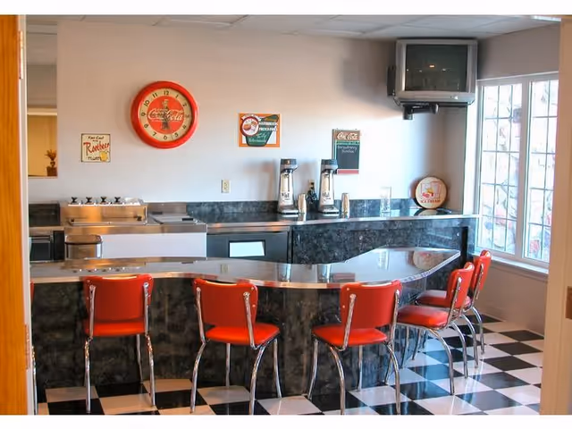 Retro-style cafe counter with red stools and checkered floor inside Heritage House Senior Living Apartments.