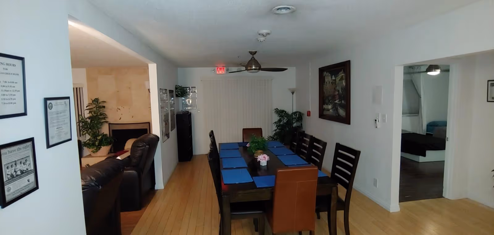 A dining room in a senior living facility with a long table and blue placemats.