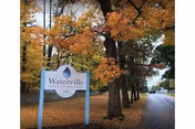 Autumn trees frame a Waterville Residential Care Center sign along a roadway.