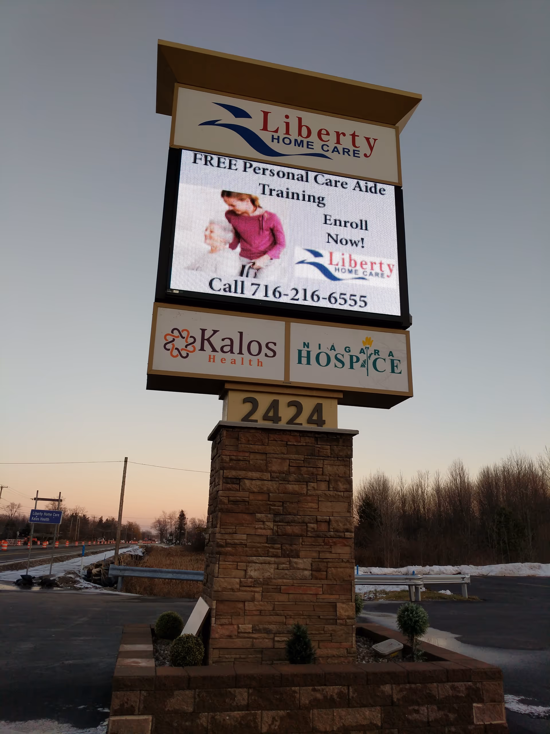 Tall, multi-panel outdoor sign for Liberty Home Care at building entrance