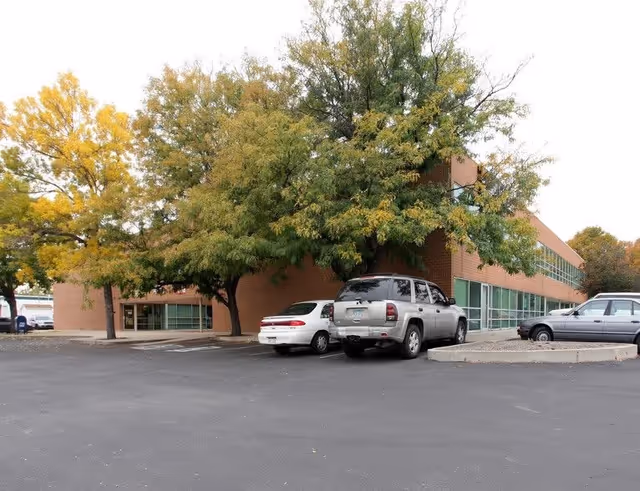 Exterior view of Angels Family senior living facility with parked cars and trees